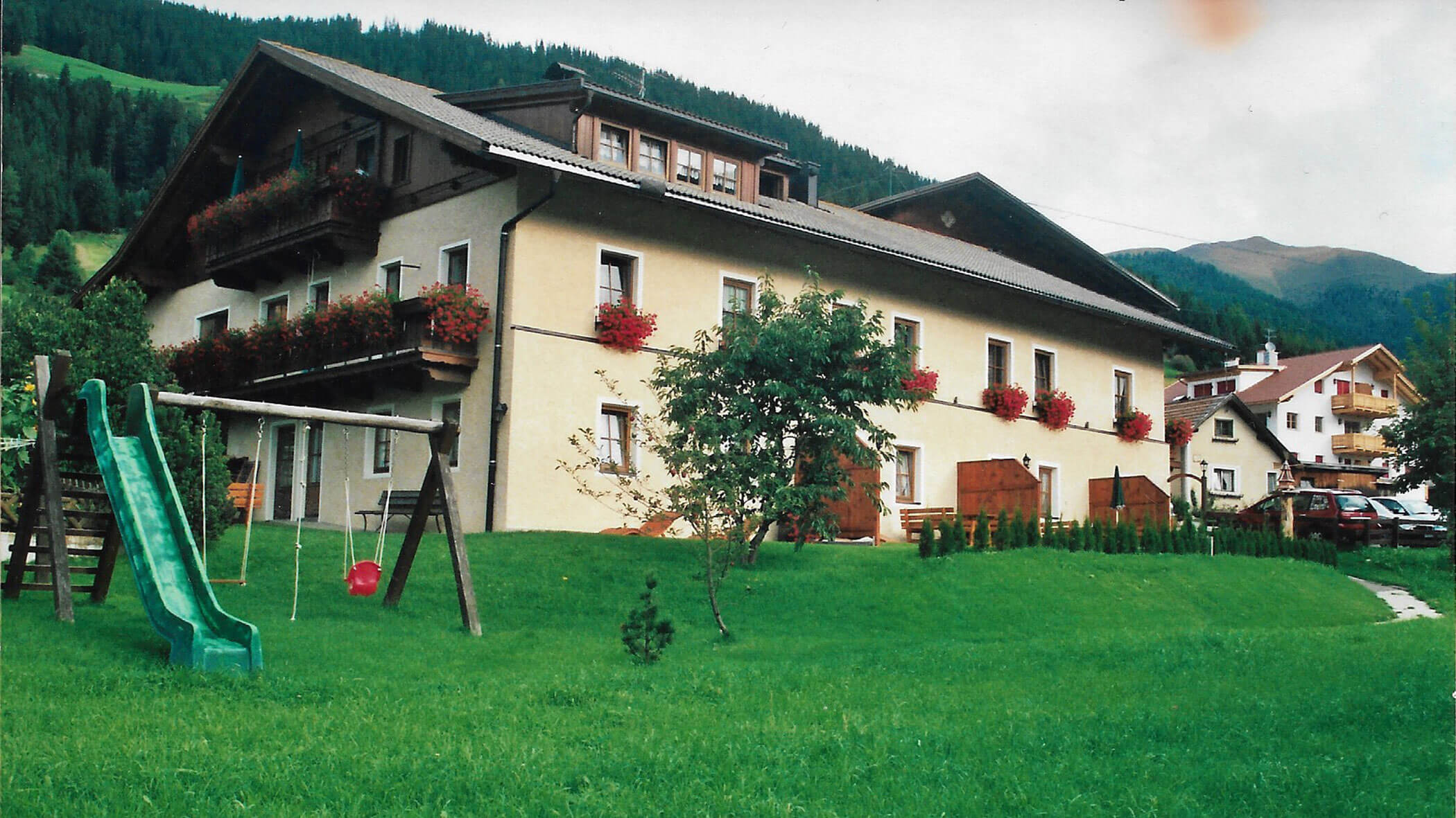 The former Hirschenhof from the outside with slide and swing in the garden