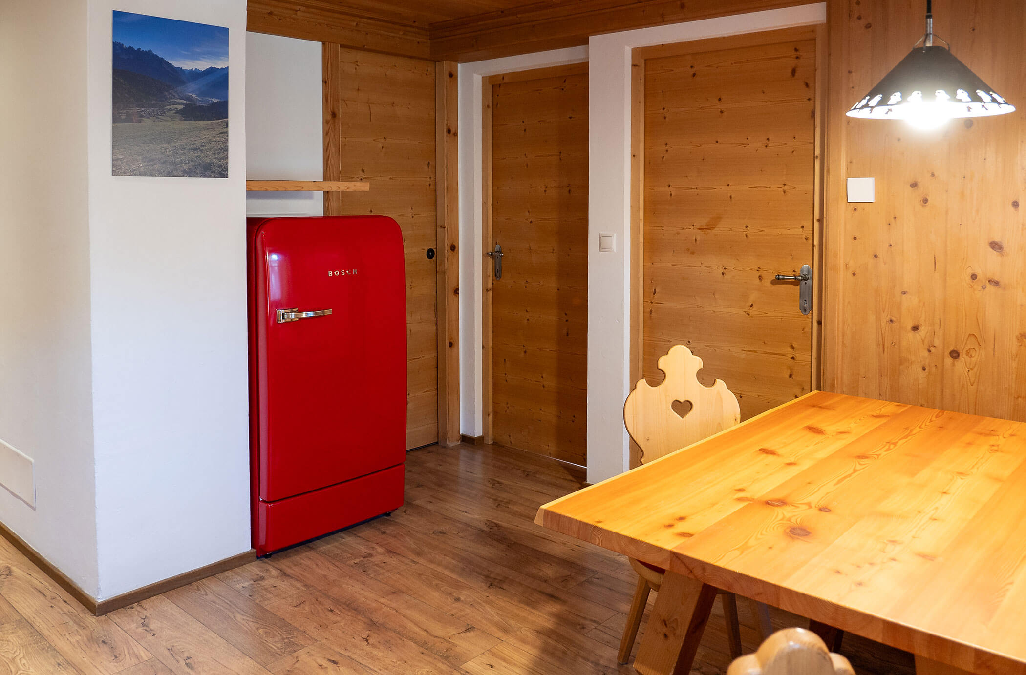 Tavolo da pranzo e frigorifero rosso accanto all'appartamento Abete Rosso - Hirschenhof