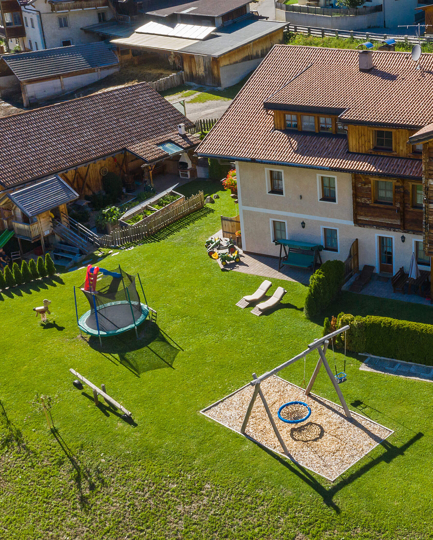 Der Hirschenhof von außen mit großen Garten mit kleinem Spielplatz