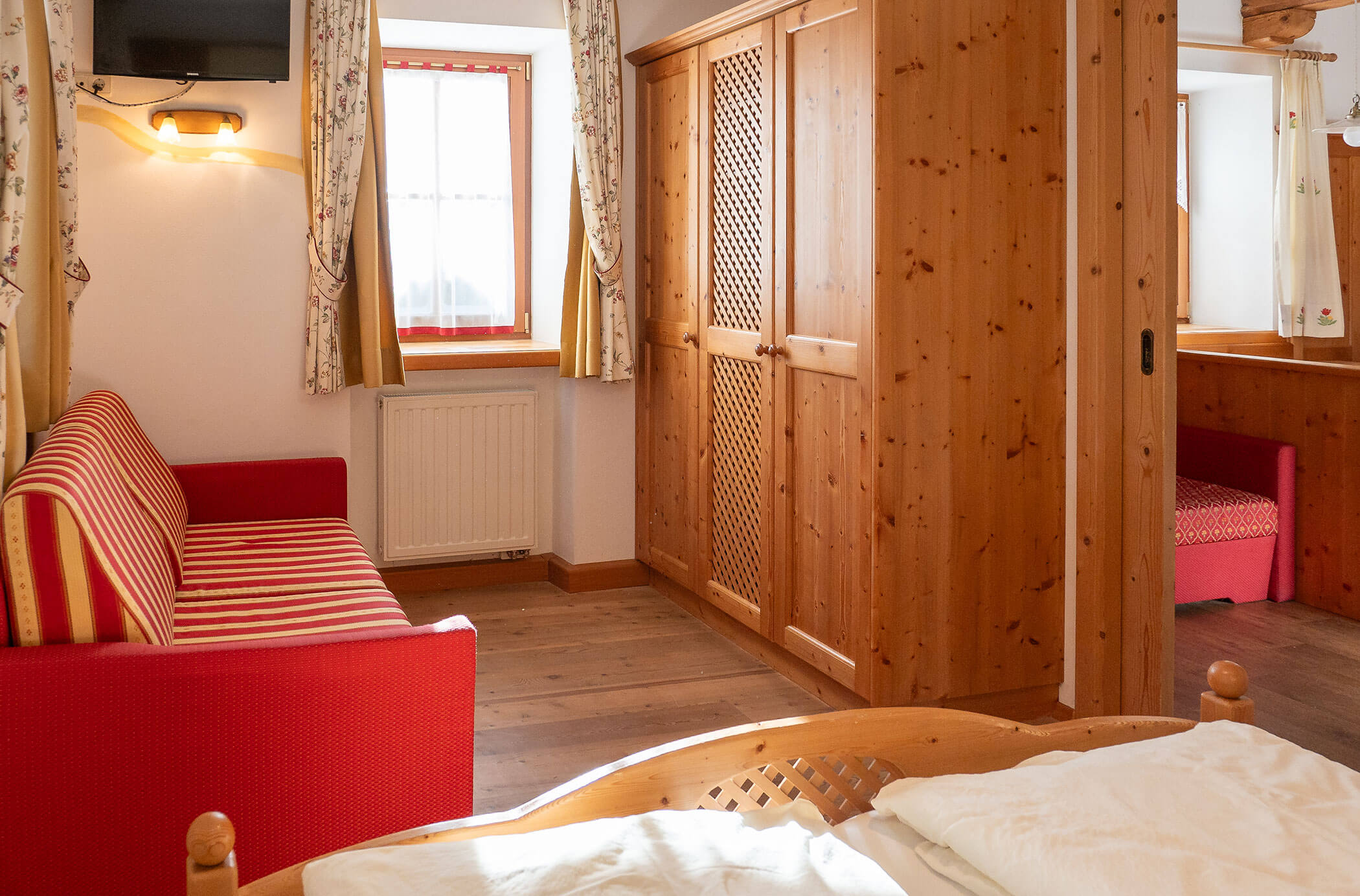 Camera da letto con letto matrimoniale e divano letto nell'appartamento Larice - Hirschenhof