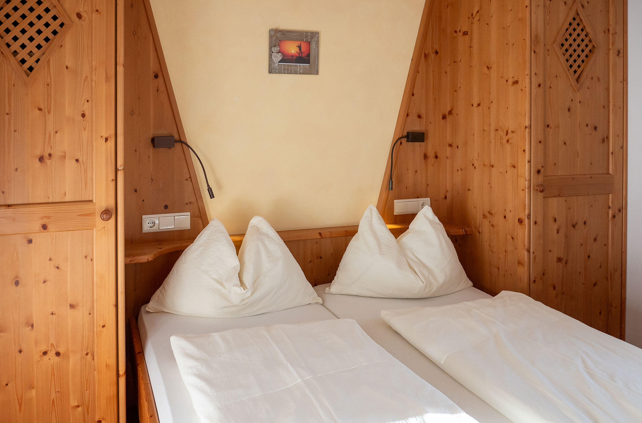 Camera da letto con letto matrimoniale e armadio in legno su entrambi i lati nell'appartamento Laces - Hirschenhof