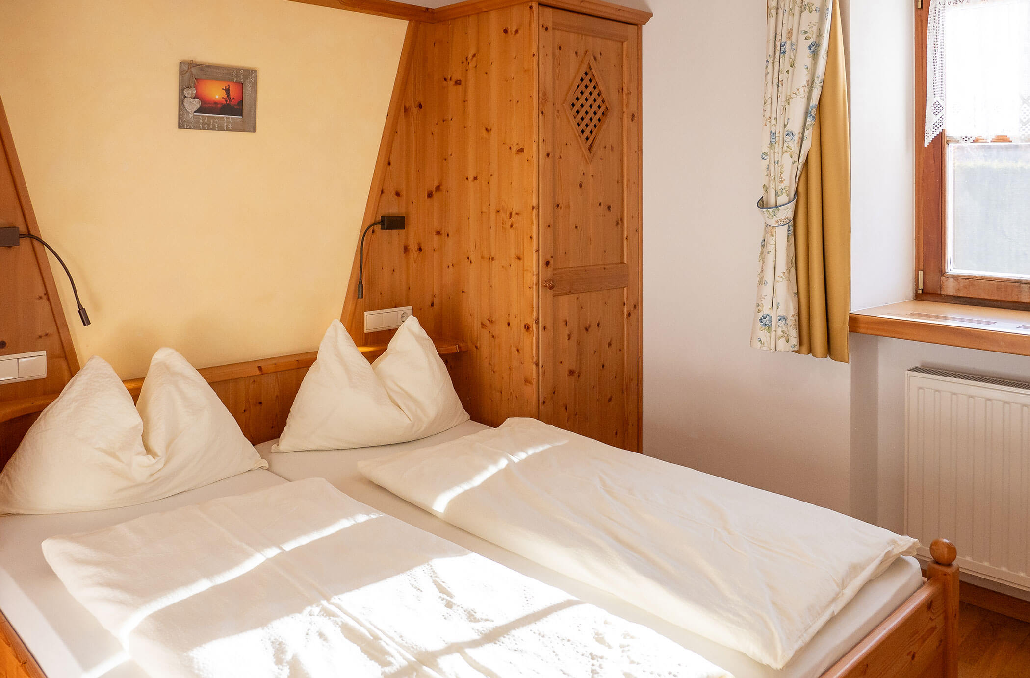 Camera da letto con letto matrimoniale e armadio in legno nell'appartamento Laces - Hirschenhof