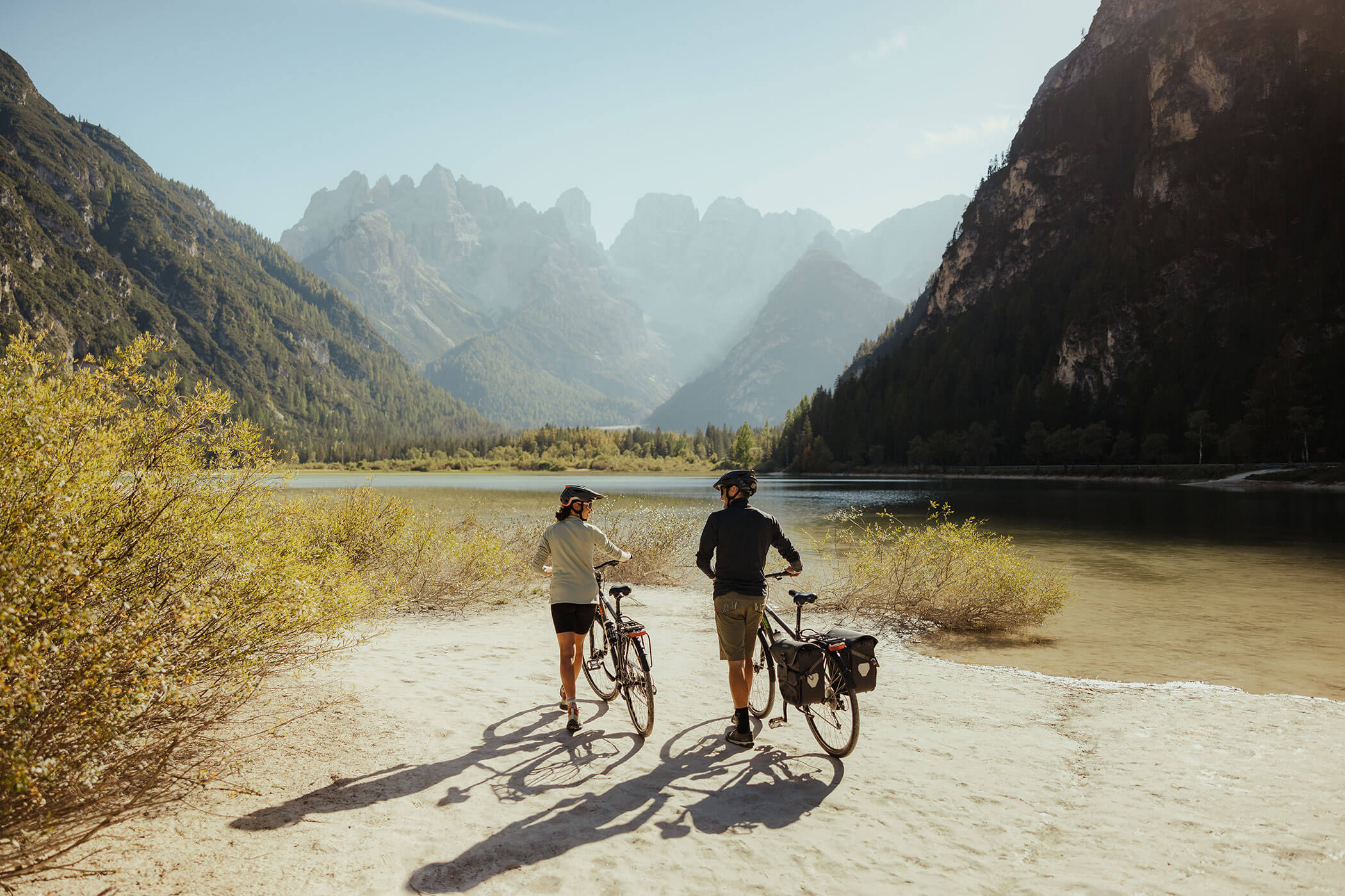 A couple walking with their bikes to Lake Dobbiaco - Hirschenhof
