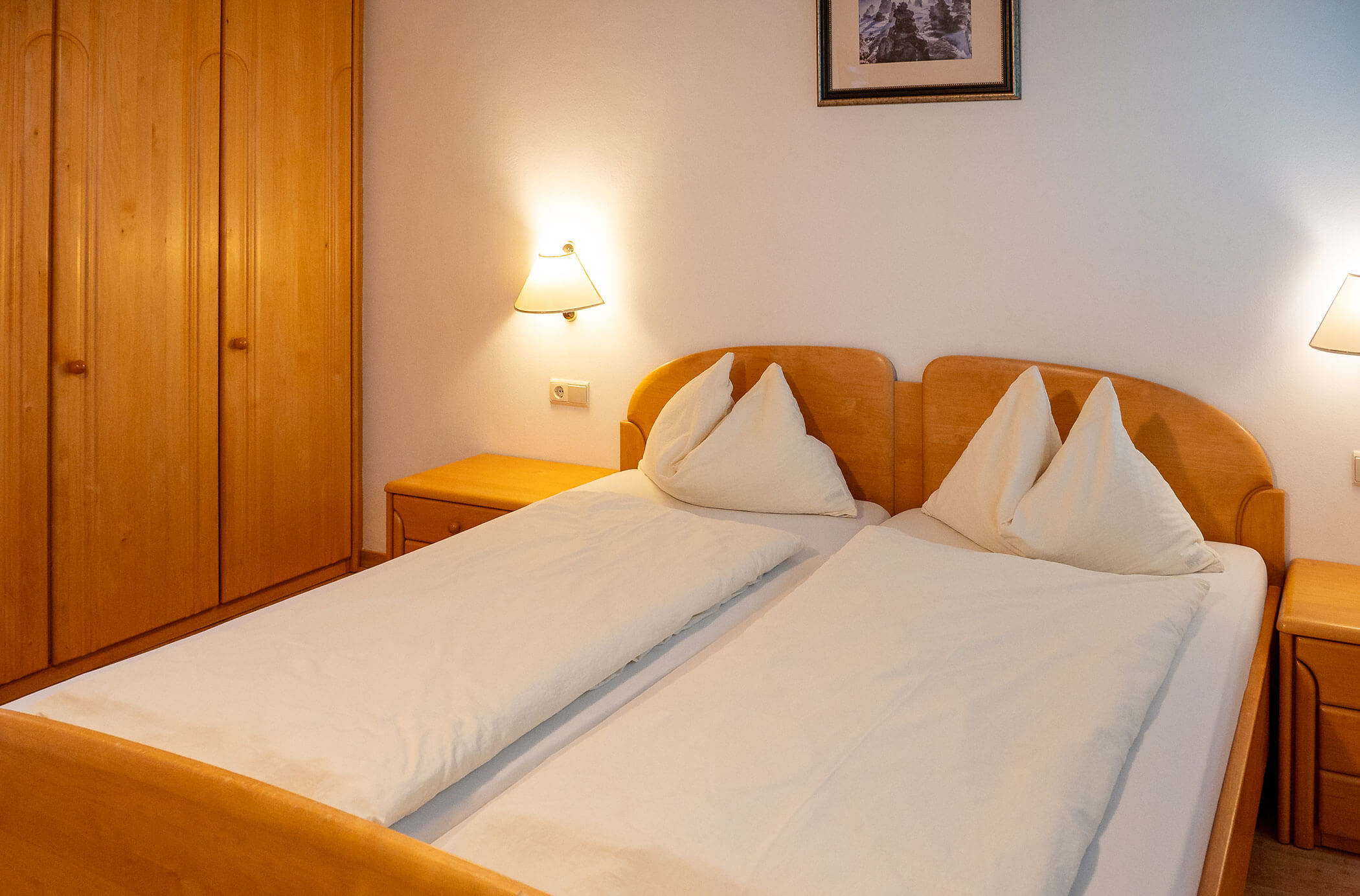 Camera da letto con letto matrimoniale e armadio in legno nell'appartamento Abete - Hirschenhof