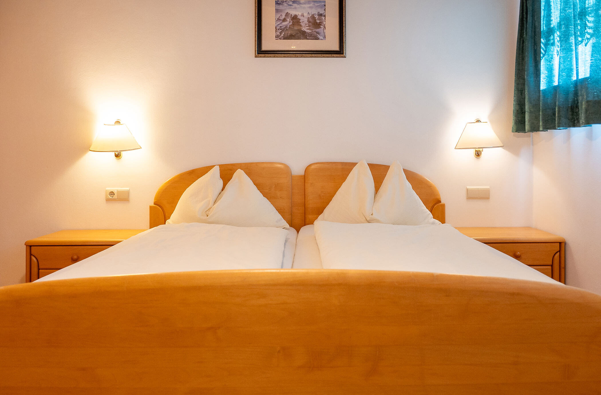 Camera da letto con letto matrimoniale e un quadro sopra di essa nell'appartamento Abete - Hirschenhof