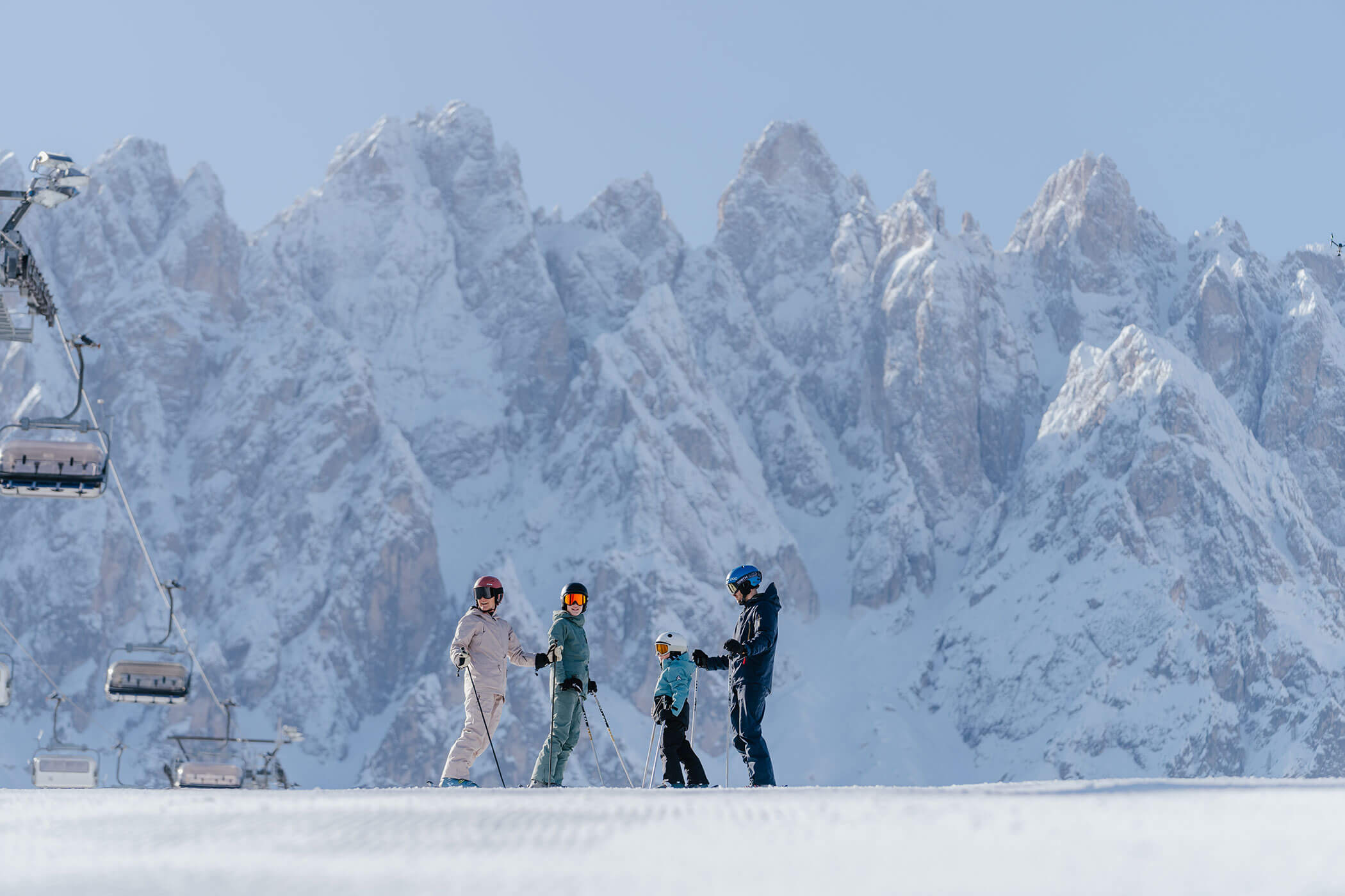 A family skiing with the snow-covered South Tyrolean Dolomites in the background - Hirschenhof