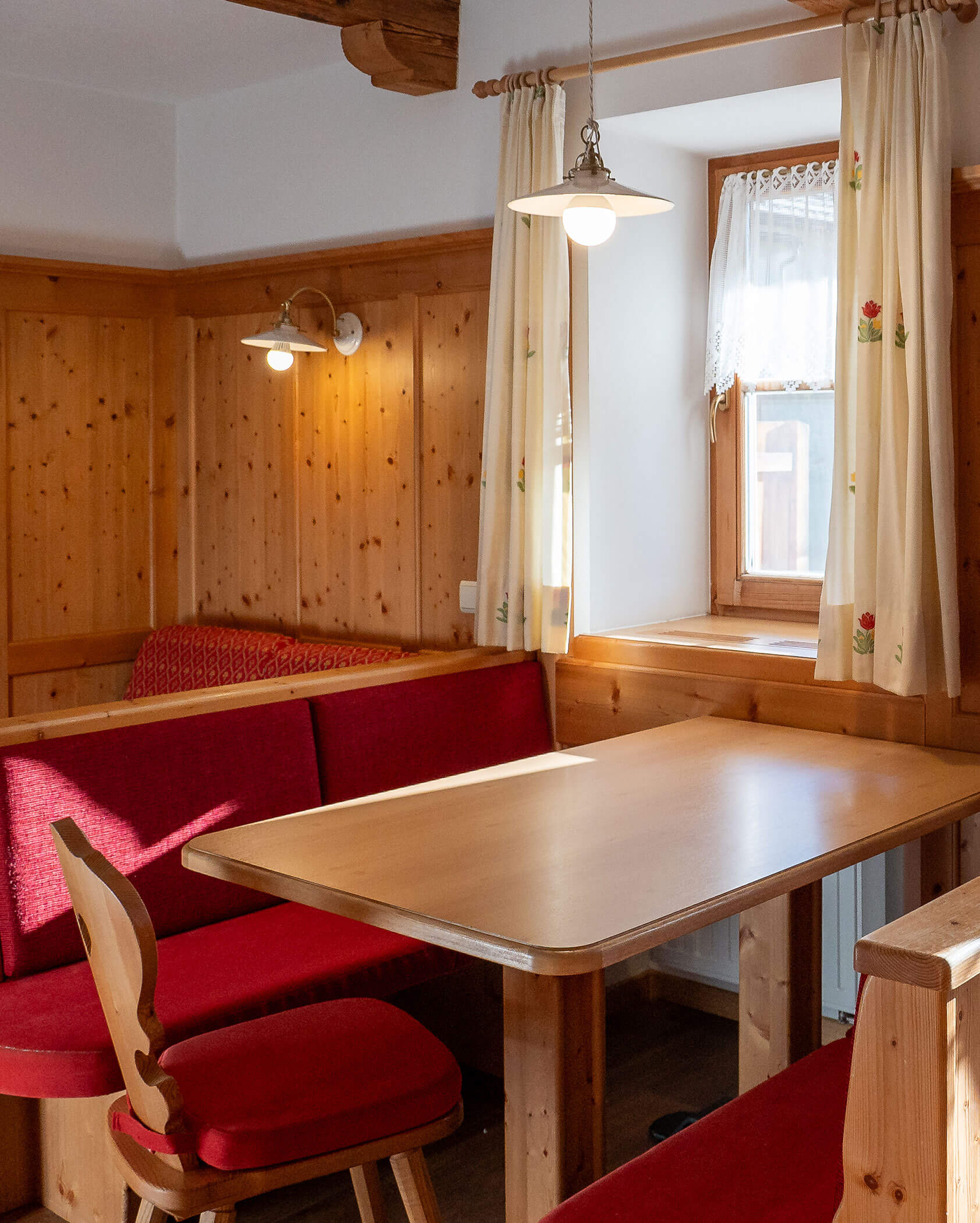 Esstisch mit Bänken und einem Stuhl im Apartment Lärche - Hirschenhof