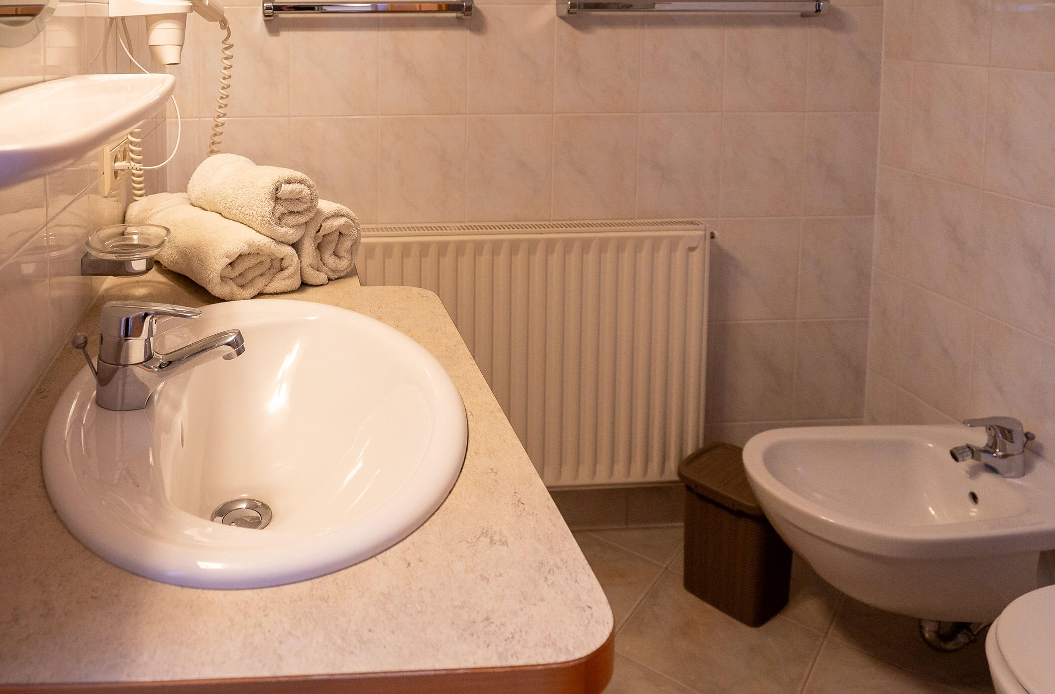 Bagno con lavabo, bidet e WC nell'appartamento Pino Cembro - Hirschenhof